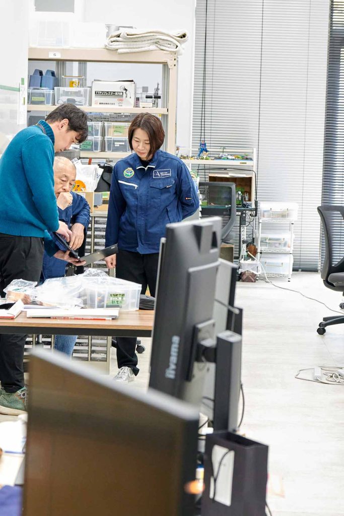 社員たちと話し合う岡島さん(右)