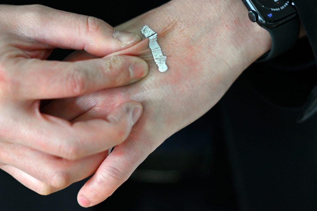 皮膚に貼った医療用の極薄シートの上に液体金属インクを塗布した様子。皮膚をつまんだりして動かしても、導電性が失われることはない