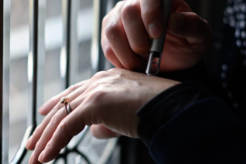 私物のマイクロスコープで、手に貼った生体電極を観察する森永さん