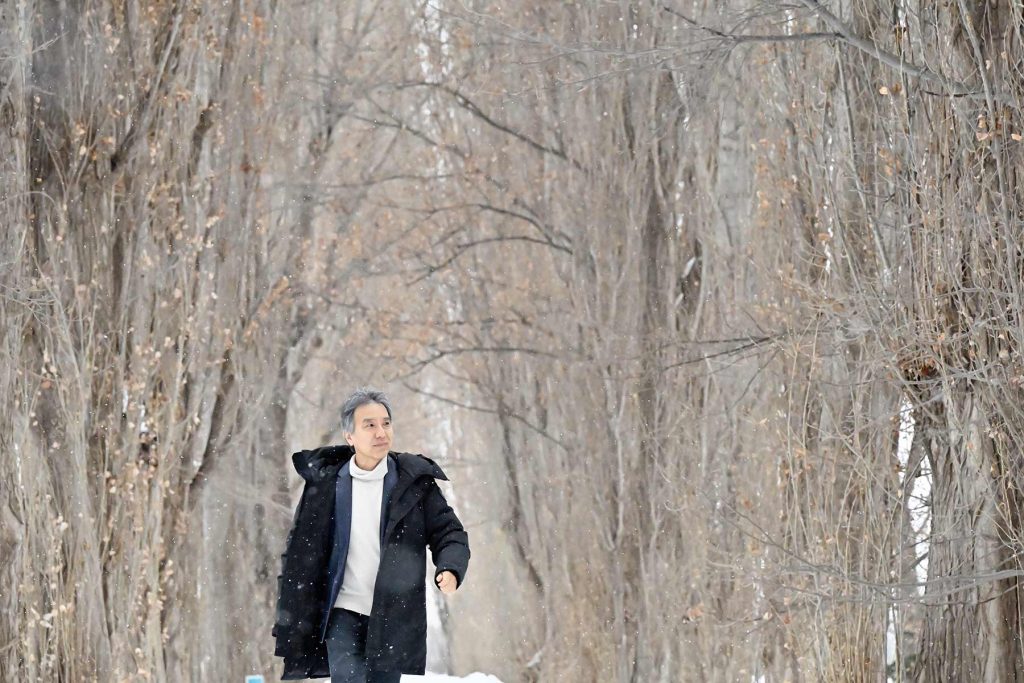 雪のポプラ並木を歩く太田泰彦先生